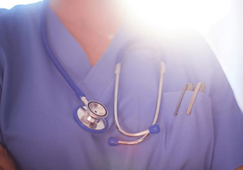Doctor in scrubs with stethoscope around neck