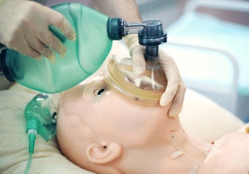 Doctor ventilating dummy patient