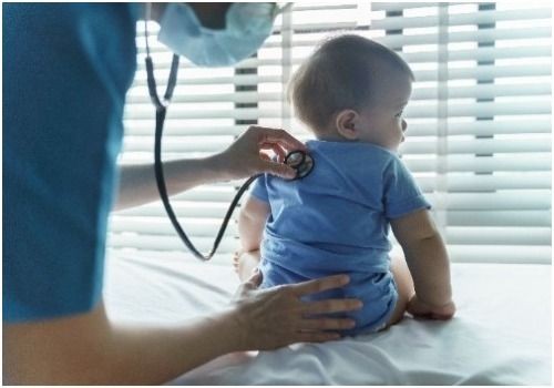Doctor holding stethoscope on baby's back