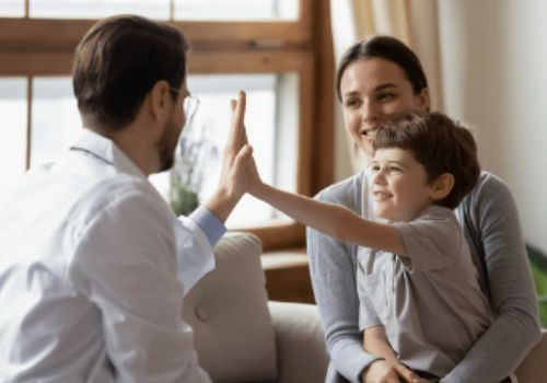 Male doctor high-fiving child