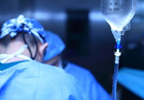 Surgeons and IV drip in hospital room