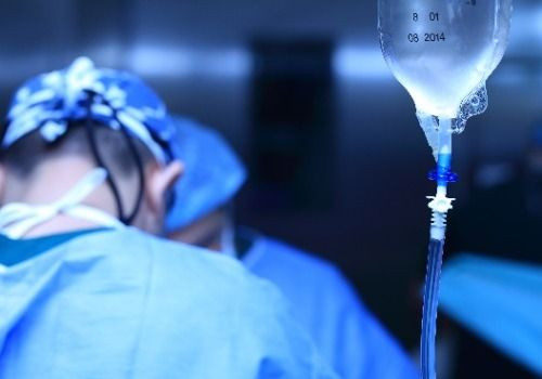 Surgeons and IV drip in hospital room