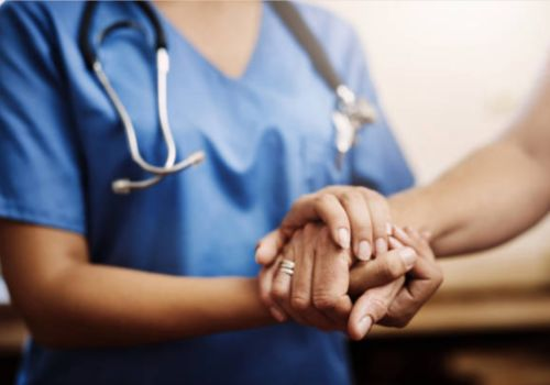 Doctor holding elderly patient's hand